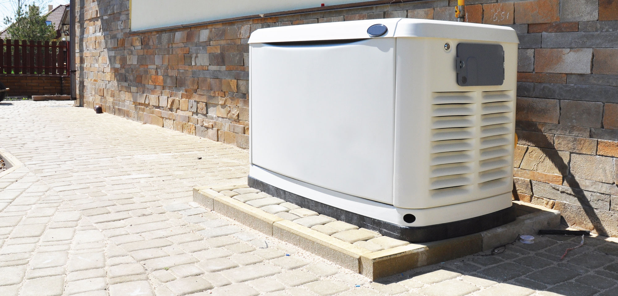 Photo of a fossil fuel standby generator on a brick patio